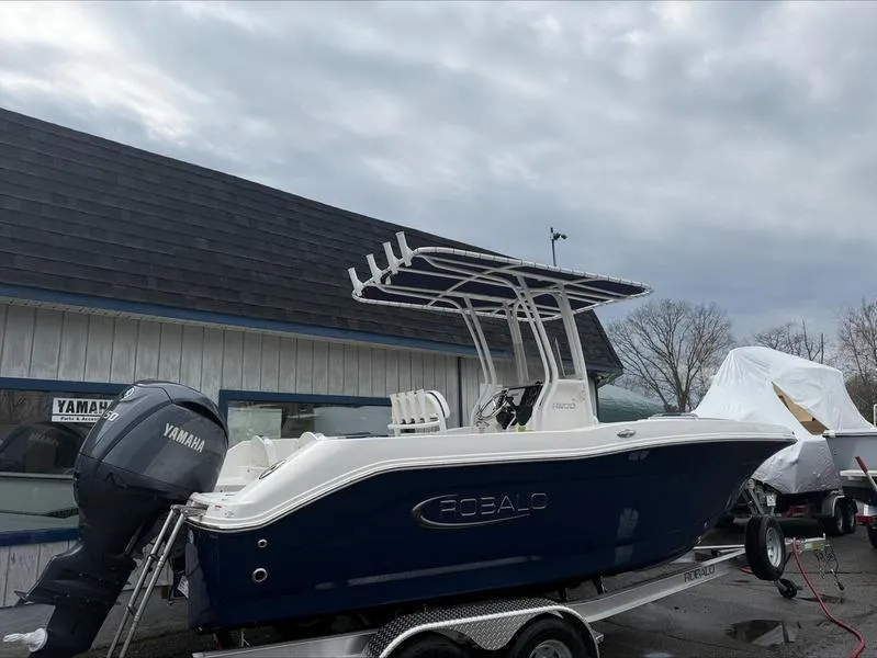 Slide: The Image of 2025 Robalo R 200 boat with Yamaha engine on trailer, parked outside a building. - 4