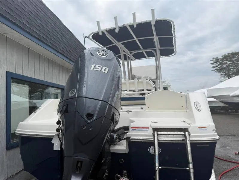 Slide: The Image of 2025 Robalo R 200 boat with Yamaha 150 outboard motor, docked near a building. - 5