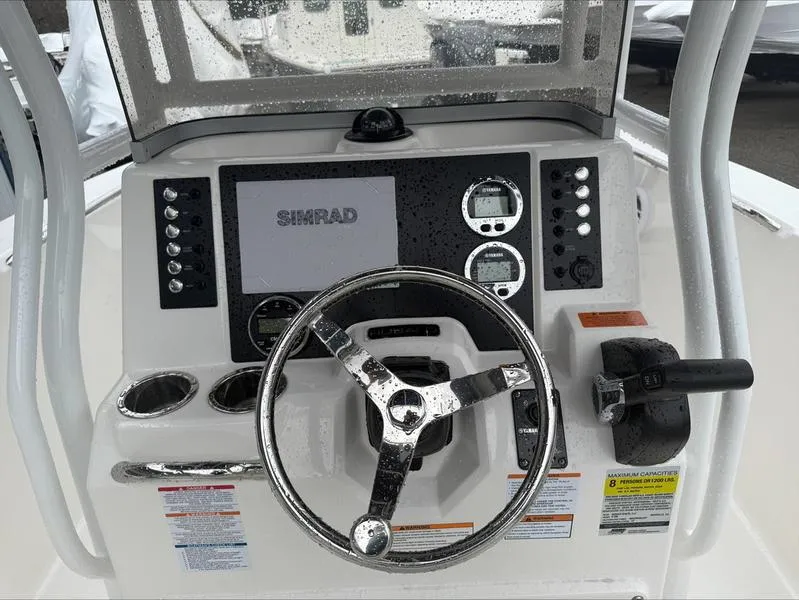 Slide: The Image of 2025 Robalo R 200 boat dashboard with Simrad display and steering wheel. - 9