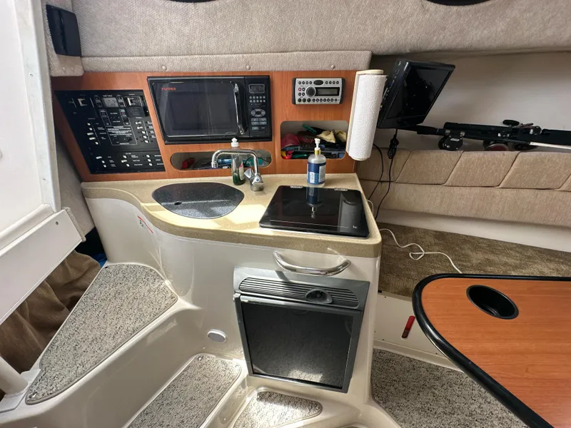 Slide: The Image of 2006 Seaswirl Striper 2901 Walkaround O/B boat interior with kitchenette and control panel. - 18
