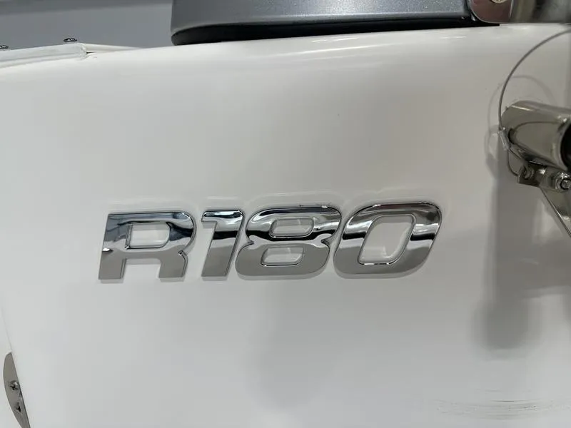 Slide: The Image of 2025 Robalo R 180 boat model emblem in chrome finish. - 12