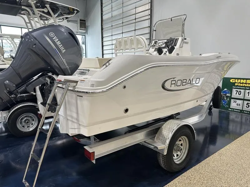 Slide: The Image of 2025 Robalo R 180 boat on trailer with Yamaha outboard motor in showroom. - 3