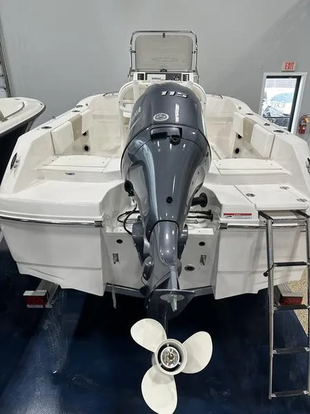 Slide: The Image of 2025 Robalo R 180 boat with powerful outboard motor, displayed indoors. - 5