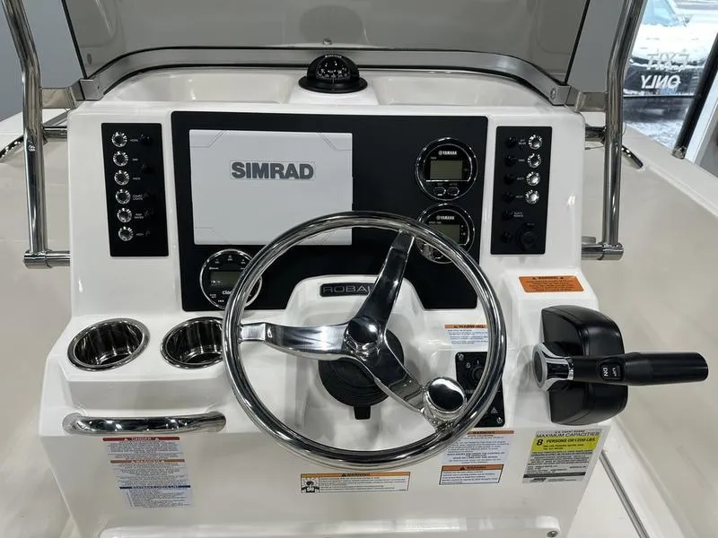 Slide: The Image of 2025 Robalo R 180 boat dashboard with Simrad navigation system and steering wheel. - 8