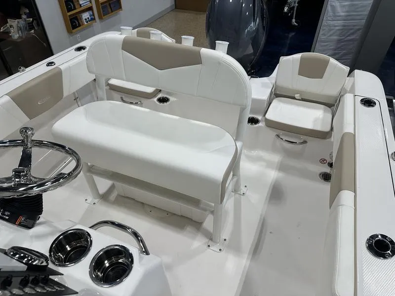 Slide: The Image of 2025 Robalo R 180 boat interior with white seating and steering wheel. - 9