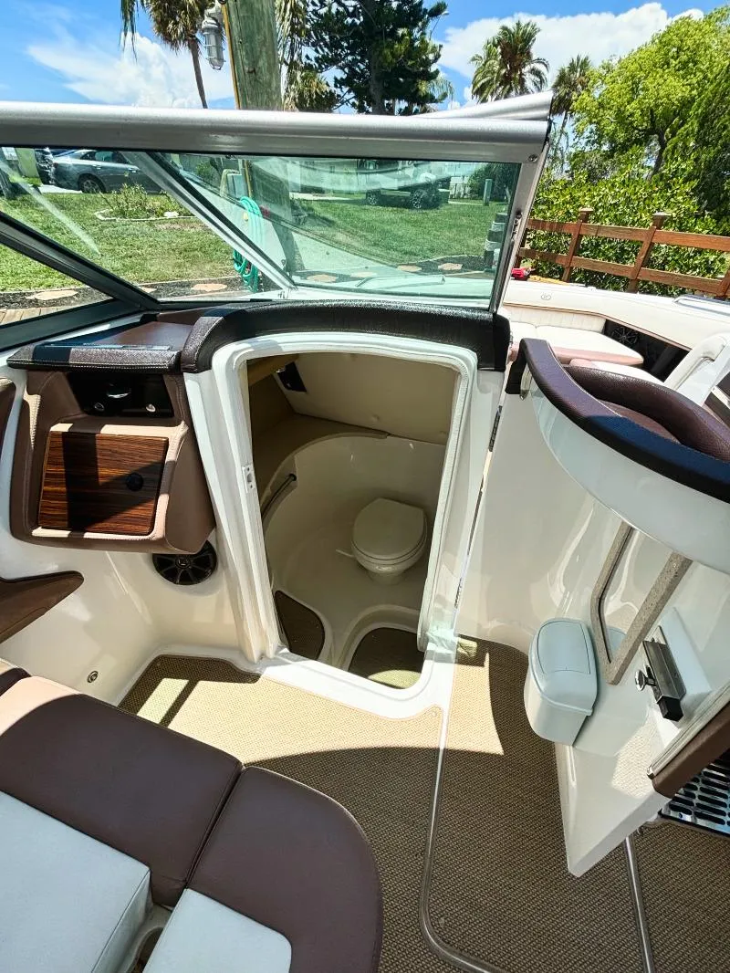 Slide: The Image of 2014 Cobalt 302 boat interior with open cabin door and seating area. - 11