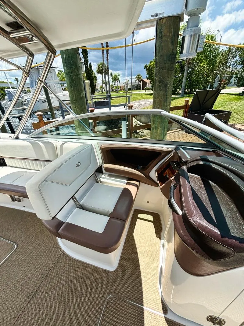 Slide: The Image of 2014 Cobalt 302 boat interior with white and brown seating, docked at marina. - 2