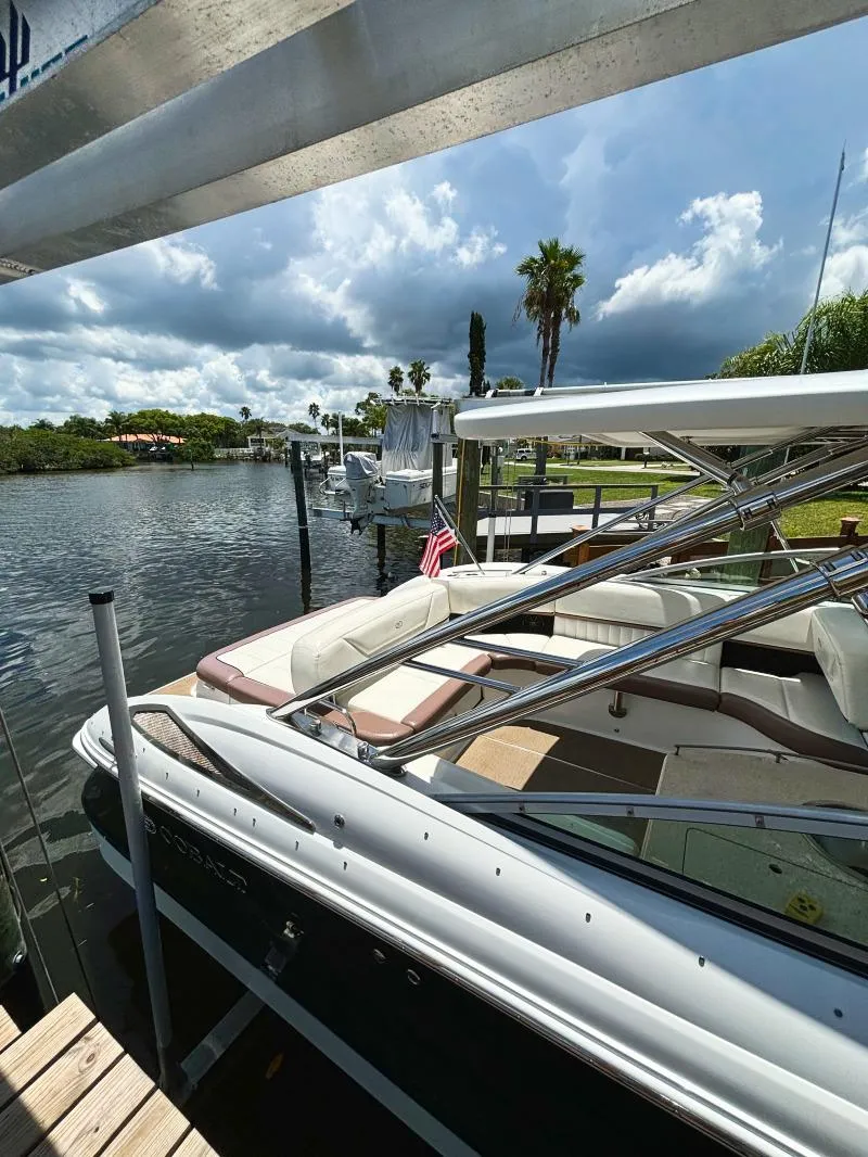 Slide: The Image of 2014 Cobalt 302 boat docked by a scenic waterfront with palm trees. - 4