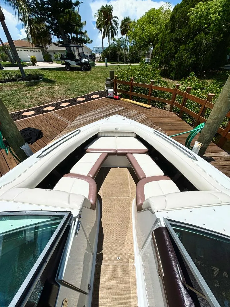Slide: The Image of 2014 Cobalt 302 boat docked at a wooden pier with lush greenery. - 5