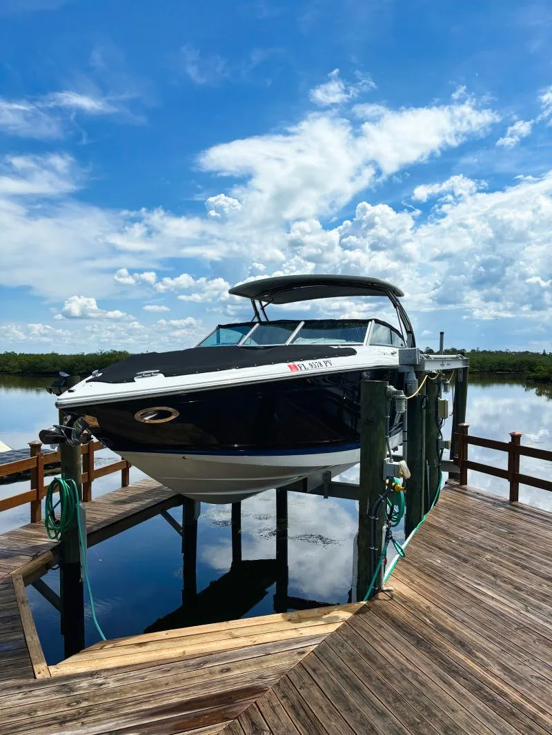 Slide: The Image of 2014 Cobalt 302 boat docked on a lift under a bright blue sky. - 7