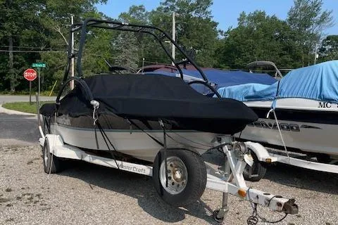 Slide: The Image of 1993 MasterCraft Prostar 205 boat on a trailer, covered and parked outdoors. - 12