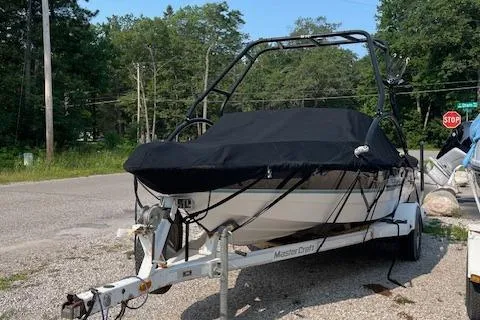 Slide: The Image of 1993 MasterCraft Prostar 205 boat on a trailer with a black cover. - 13