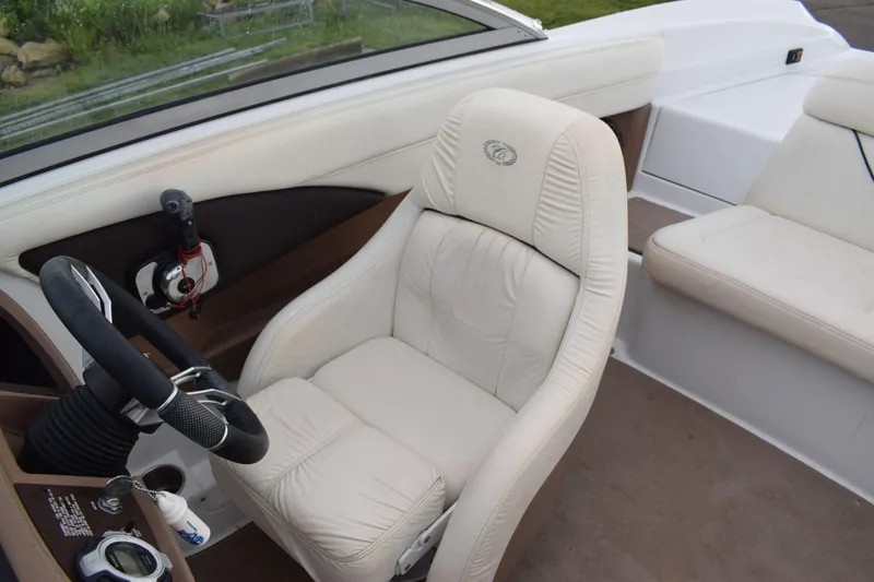 Slide: The Image of 2013 Cobalt 210 WSS boat interior with white leather captain's chair and steering wheel. - 10