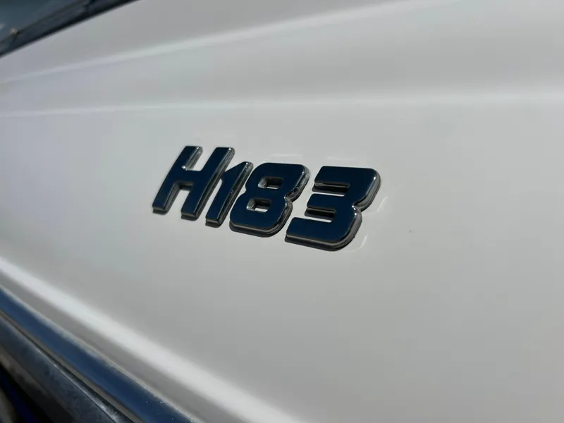 Slide: The Image of 2007 Four Winns 183 Horizon F&S boat on trailer, parked outside blue building. - 1