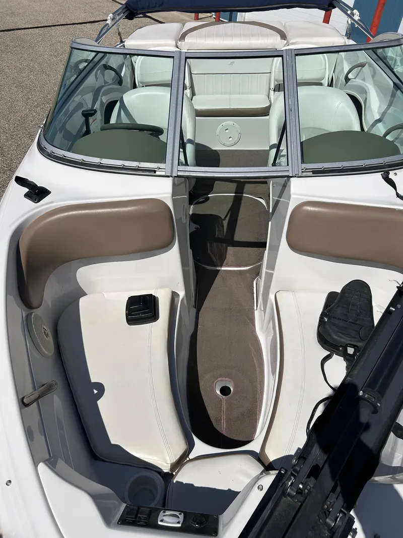 Slide: The Image of 2007 Four Winns 183 Horizon F&S boat on trailer, parked outside blue building. - 2