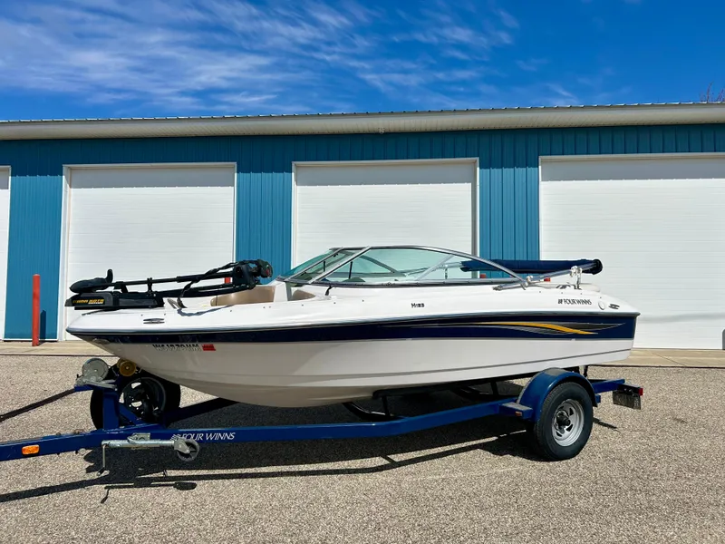 Slide: The Image of 2007 Four Winns 183 Horizon F&S boat on trailer, parked near blue building. - 8