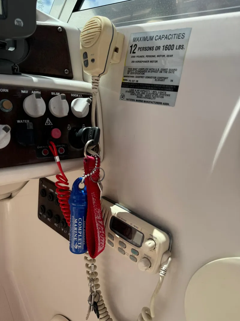 Slide: The Image of 1999 Hurricane 232 FUN DECK boat dashboard with controls and capacity label. - 14