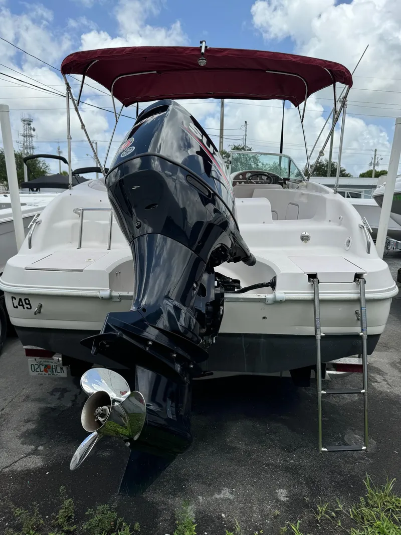 Slide: The Image of 1999 Hurricane 232 Fun Deck boat with outboard motor and red canopy. - 4