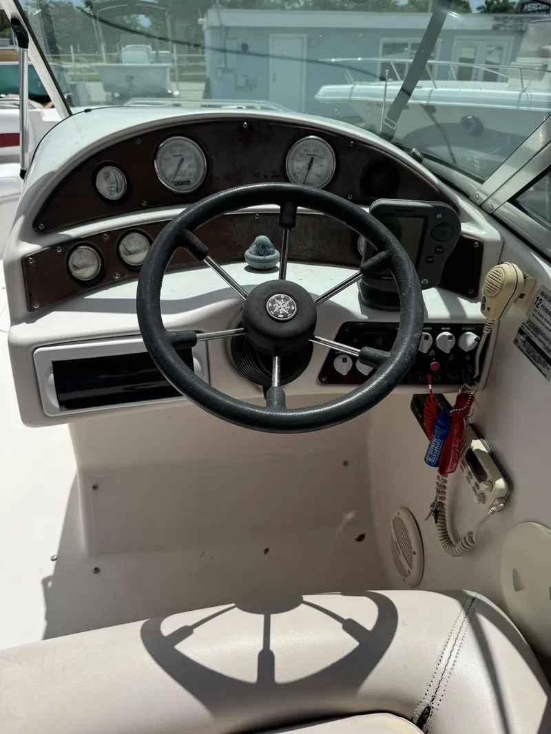 Slide: The Image of 1999 Hurricane 232 Fun Deck boat dashboard with steering wheel and control panel. - 8