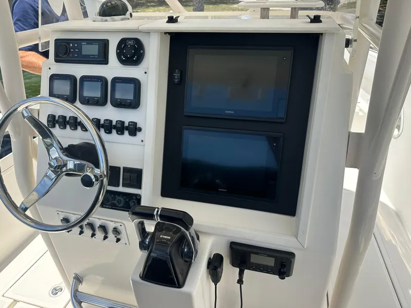 Slide: The Image of 2013 Stamas 317 Tarpon boat dashboard with steering wheel and electronic controls. - 19