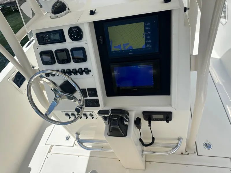 Slide: The Image of 2013 Stamas 317 Tarpon boat dashboard with navigation screens and steering wheel. - 20