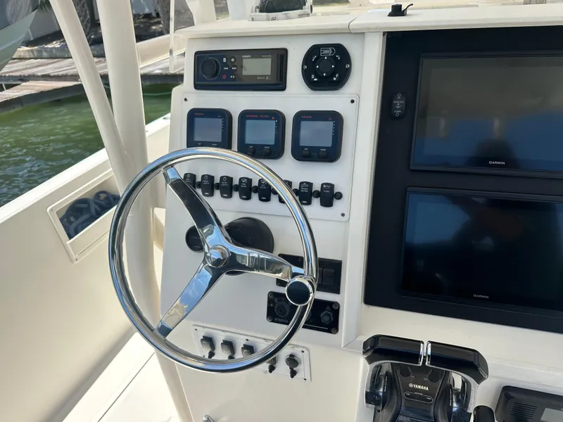 Slide: The Image of 2013 Stamas 317 Tarpon boat dashboard with steering wheel and control panel. - 21