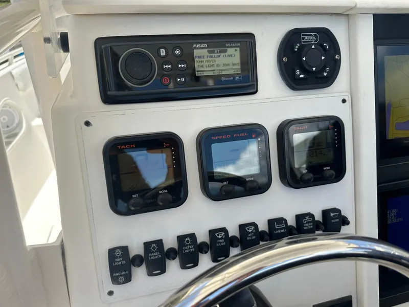 Slide: The Image of Control panel of a 2013 Stamas 317 Tarpon boat with gauges and radio. - 24