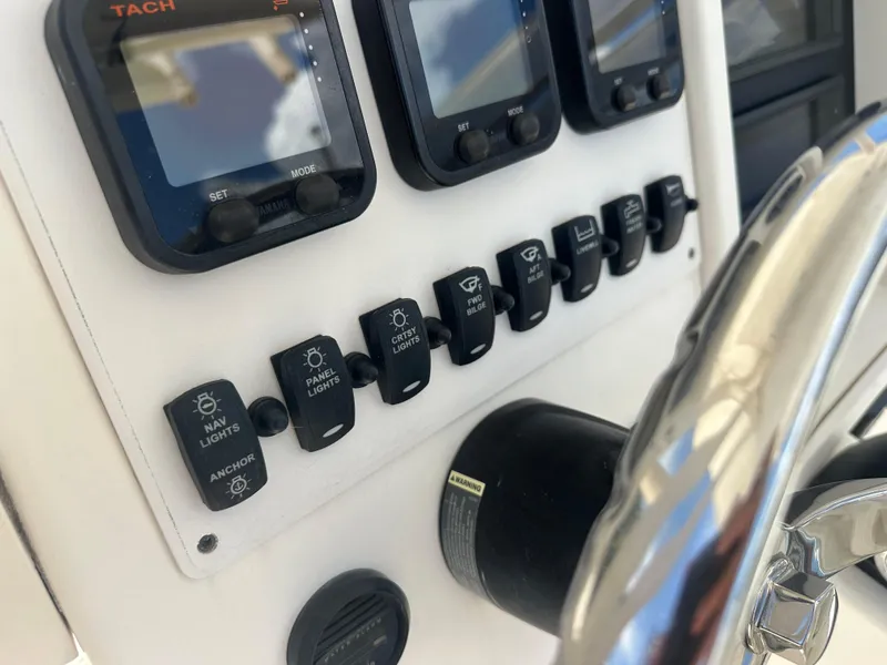 Slide: The Image of Control panel of a 2013 Stamas 317 Tarpon boat with switches and gauges. - 25