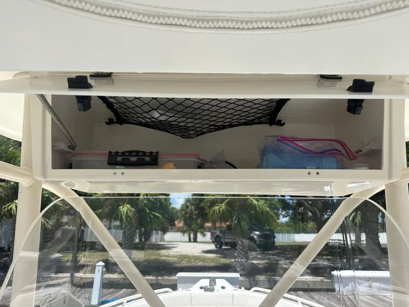 Slide: The Image of Storage compartment of a 2013 Stamas 317 Tarpon boat with netting and supplies. - 31