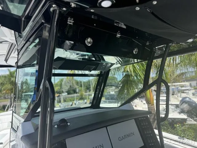 Slide: The Image of 2025 Blackfin 332cc boat storage compartment with open lid and two white buckets. - 34