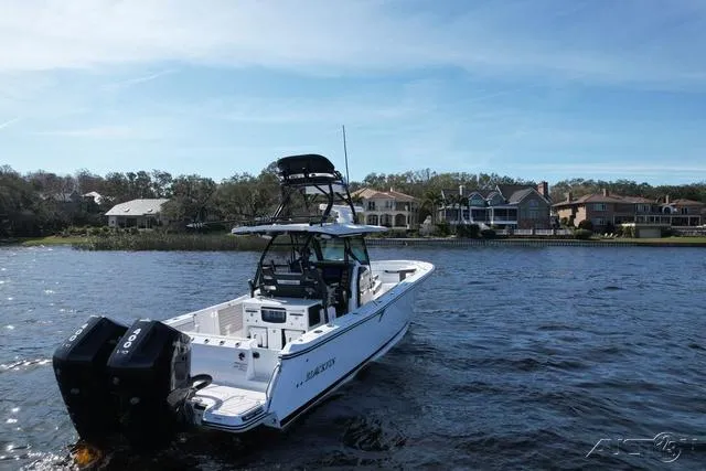 Slide: The Image of 2025 Blackfin 332cc boat with Mercury outboard engine on trailer, palm trees in background. - 5