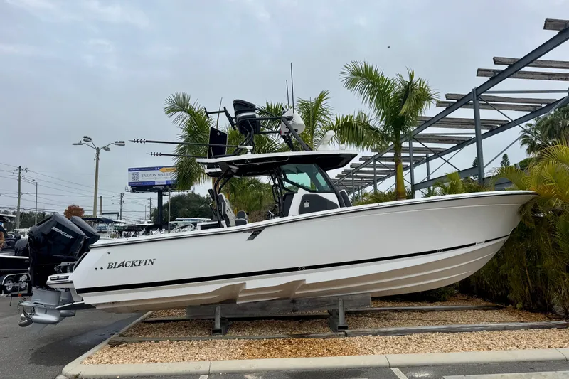 Slide: The Image of 2025 Blackfin 332 CC boat displayed outdoors with palm trees in the background. - 60