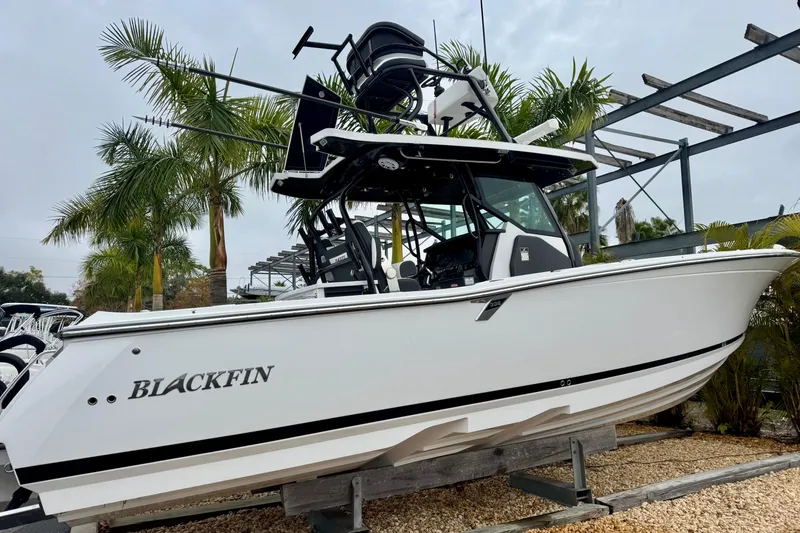 Slide: The Image of 2025 Blackfin 332 CC boat displayed outdoors with palm trees in the background. - 62