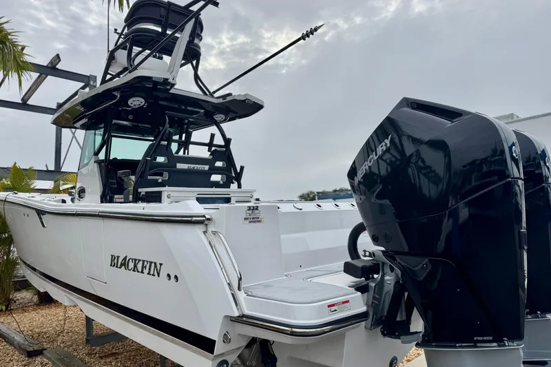 Slide: The Image of 2025 Blackfin 332 CC boat with Mercury engines, docked under cloudy skies. - 65