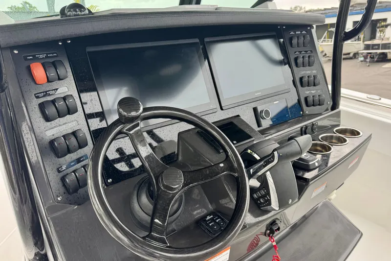 Slide: The Image of 2025 Blackfin 332 CC boat dashboard with steering wheel and dual screens. - 78