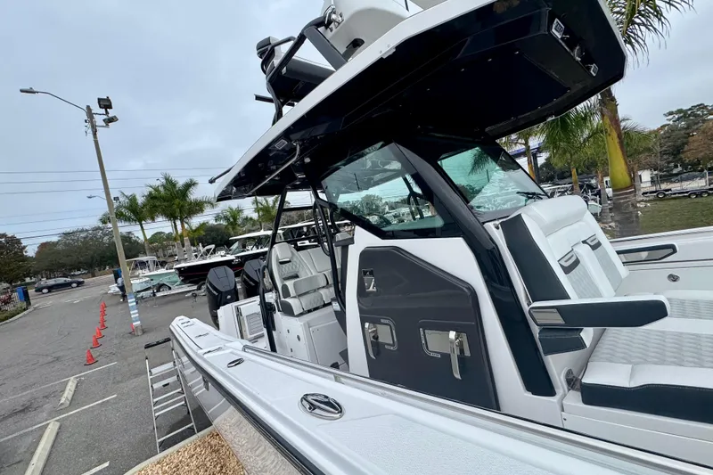 Slide: The Image of 2025 Blackfin 332 CC boat with sleek design, parked outdoors near palm trees. - 85