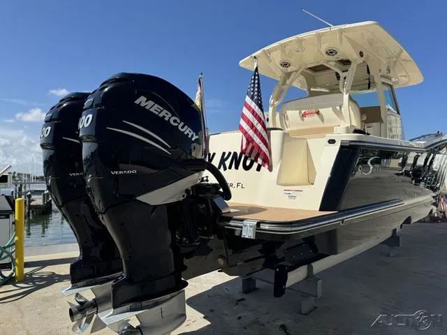 Slide: The Image of 2022 Scout 330 LXF boat with twin Mercury Verado engines docked. - 12
