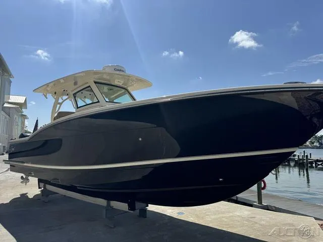Slide: The Image of 2022 Scout 330 LXF boat docked under a clear blue sky. - 30