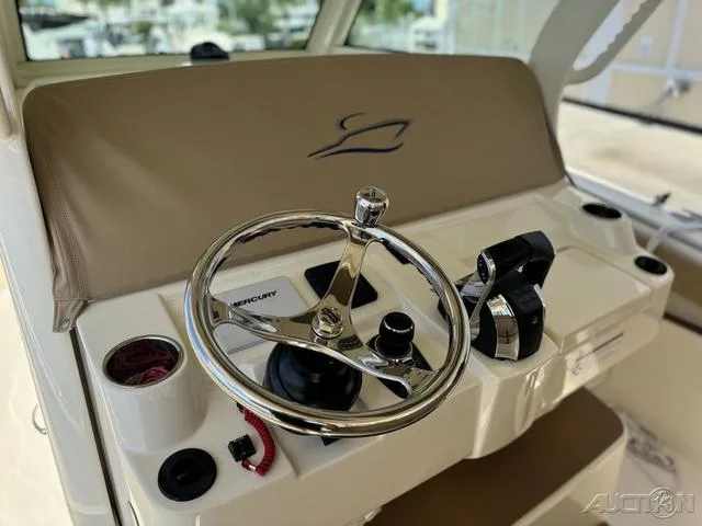 Slide: The Image of 2022 Scout 330 LXF boat helm with steering wheel and controls. - 36