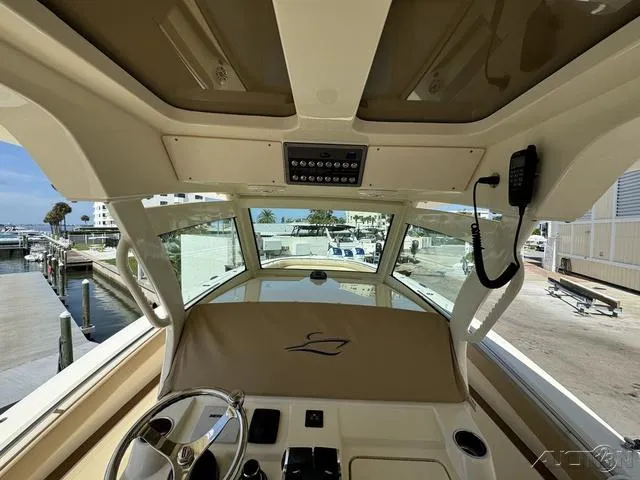 Slide: The Image of 2022 Scout 330 LXF boat helm with steering wheel and control panel. - 41