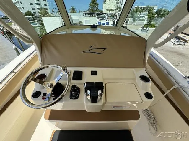 Slide: The Image of 2022 Scout 330 LXF boat helm station with steering wheel and controls. - 42