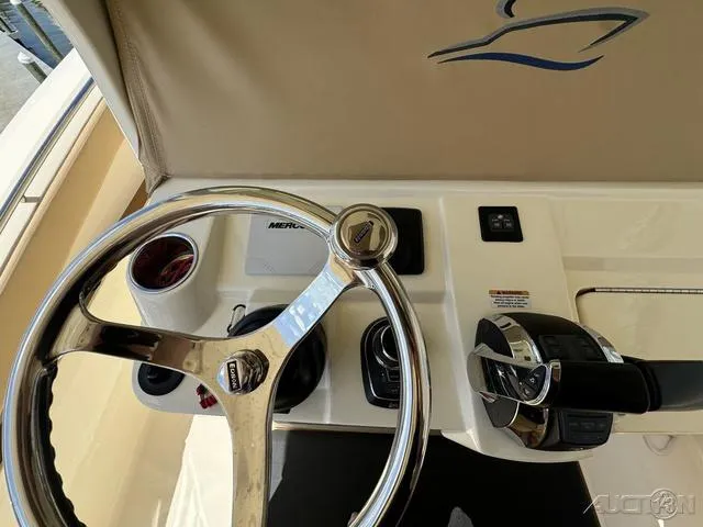 Slide: The Image of 2022 Scout 330 LXF boat helm with steering wheel and controls. - 43