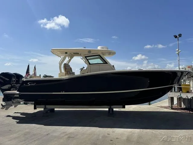 Slide: The Image of 2022 Scout 330 LXF boat on display at a marina under a clear blue sky. - 7