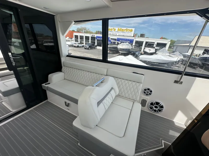 Slide: The Image of Luxurious seating area on 2025 Regal 36 Grande Coupe yacht with cup holders and quilted upholstery. - 12