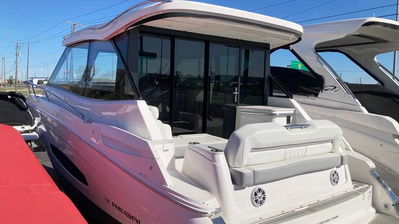 Slide: The Image of 2025 Regal 36 Grande Coupe luxury yacht, sleek design, docked outdoors. - 2