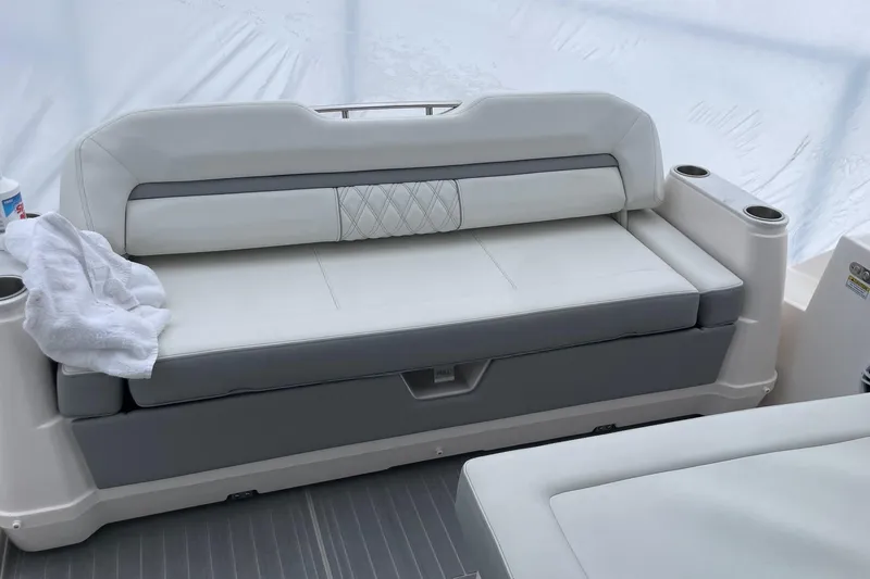 Slide: The Image of 2025 Regal 36 Grande Coupe boat interior with white cushioned seating and cup holders. - 63