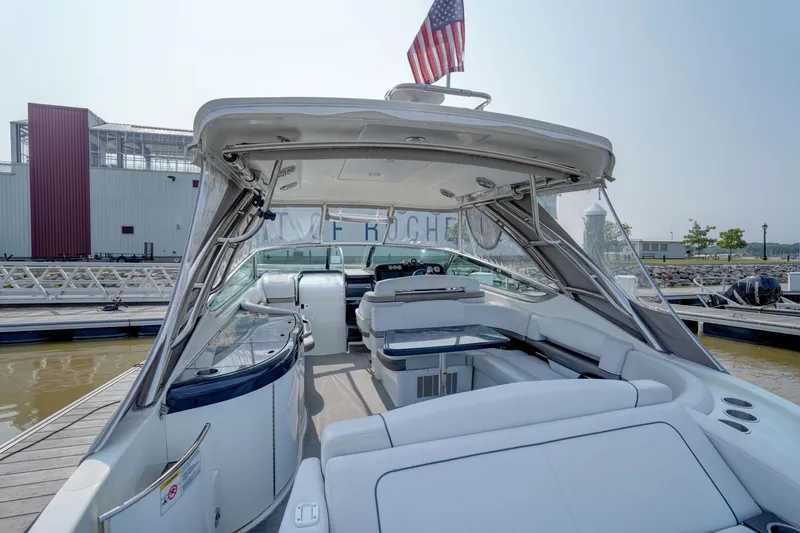 Slide: The Image of 2017 Formula 370 Super Sport boat with spacious seating and American flag, docked at marina. - 17
