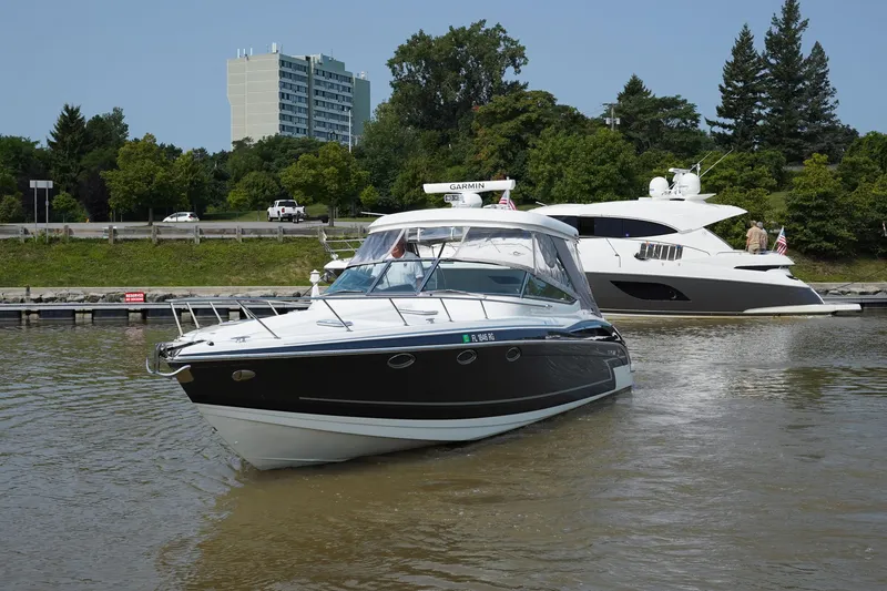 Slide: The Image of 2017 Formula 370 Super Sport boat docked on a calm river with trees and buildings in the background. - 5