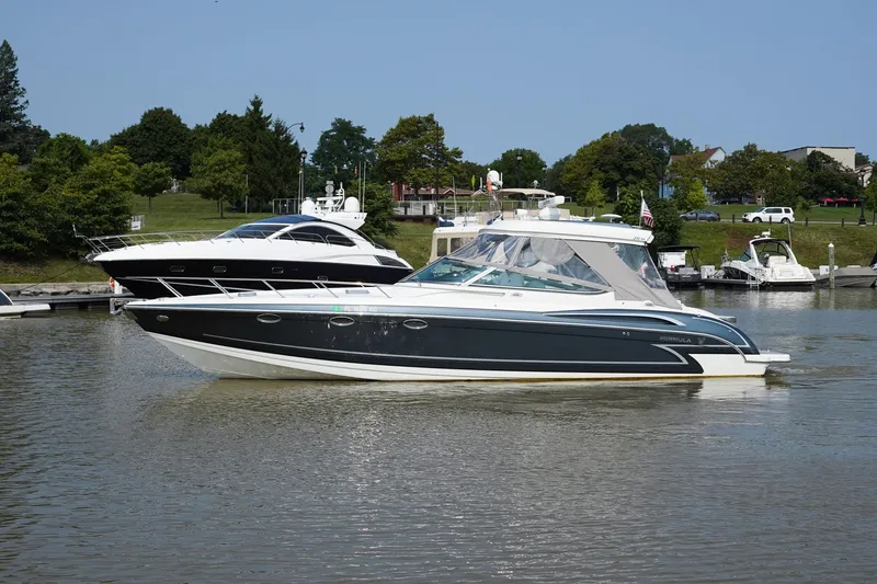 Slide: The Image of 2017 Formula 370 Super Sport boat cruising on a calm river near a marina. - 6