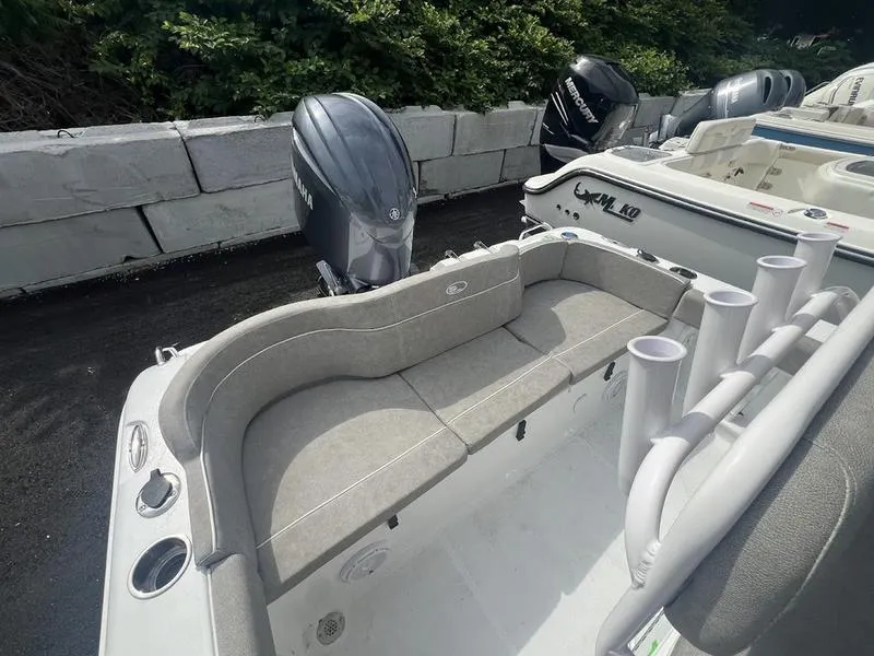 Slide: The Image of 2025 Sea Hunt Ultra 219 boat with cushioned seating and outboard motor. - 4